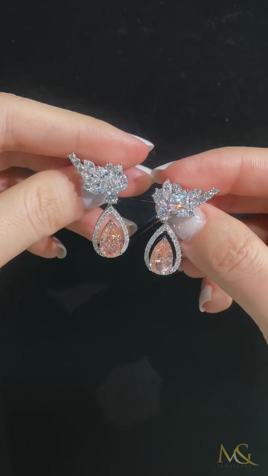 M&G Jewellery orange-pink diamond earrings shown in hand
